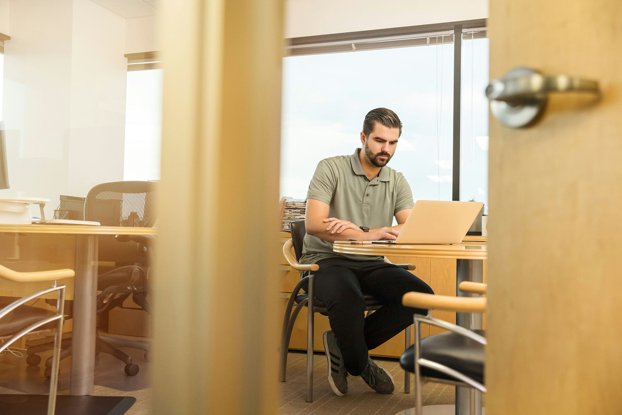 Accounting professional working on laptop to review financial reporting in office